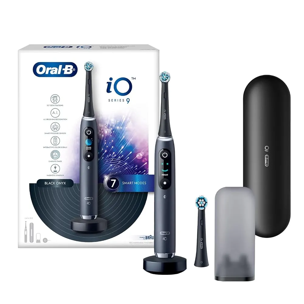 An electric toothbrush resting on a clean bathroom sink counter