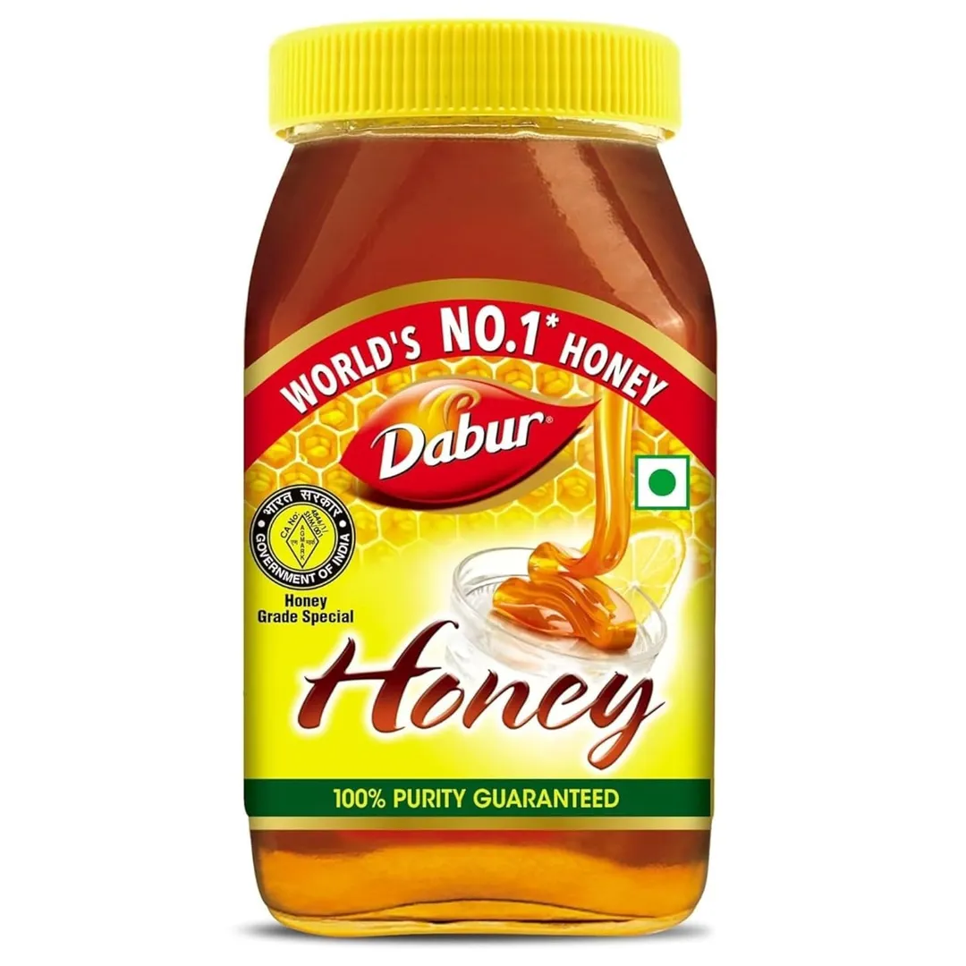 Jar of golden honey with a honey dipper